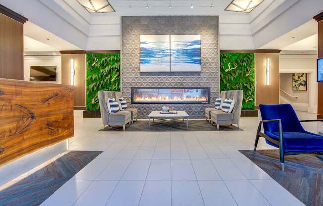 A modern living room with a fireplace and a painting above it.