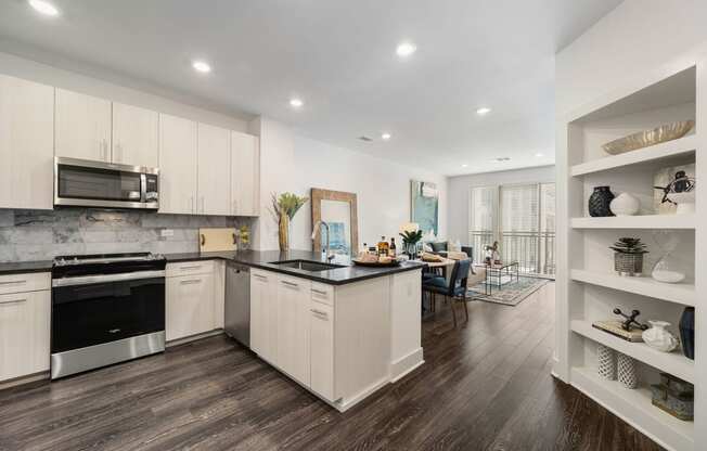 a kitchen with white cabinets and a black counter top