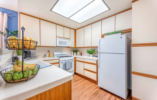 a kitchen with white cabinets and a white refrigerator