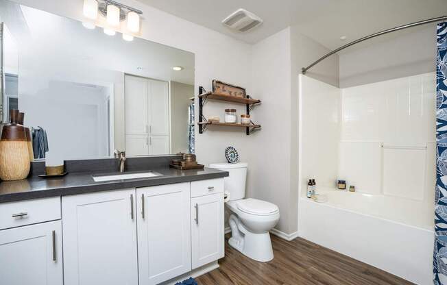 A white bathroom with a sink, toilet, and bathtub.