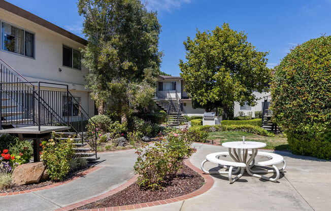 a patio with a table and chairs in front of a building