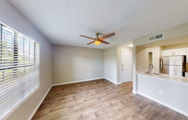 a living room with a large window and a ceiling fan