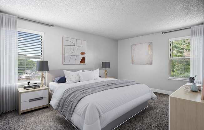 A bedroom with a large bed, two lamps, and two pieces of artwork on the wall.