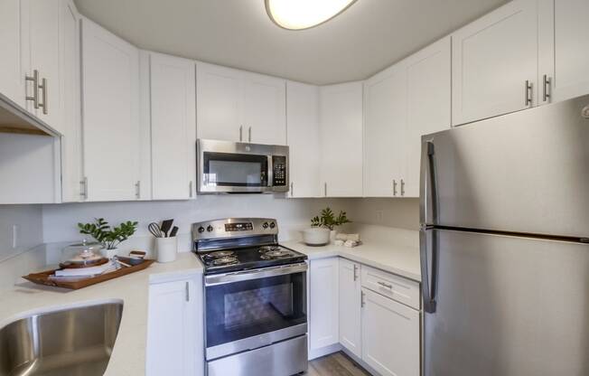 a kitchen with white cabinets and stainless steel appliances