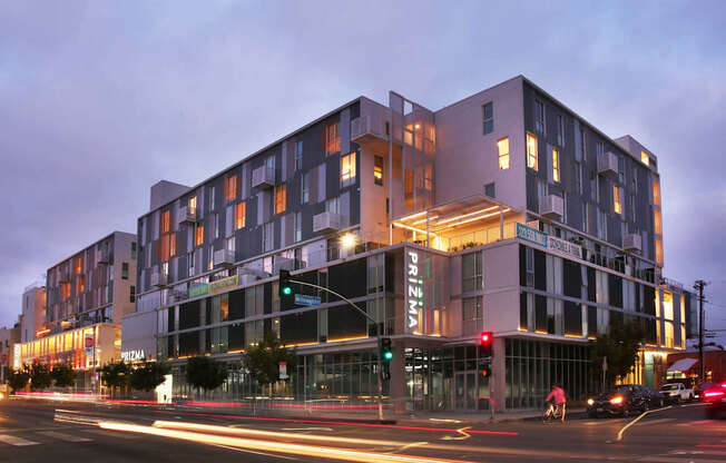 A modern building with a glass facade and a lit up sign that reads "PRINZA".