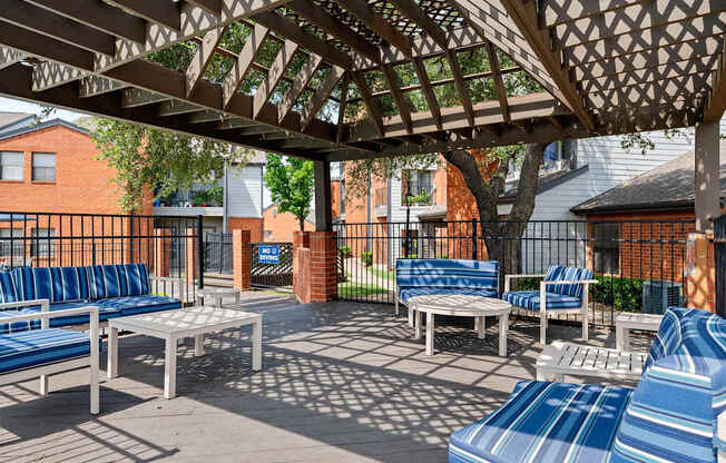 Pergola-covered outdoor lounge with cushioned seating beside the pool deck.