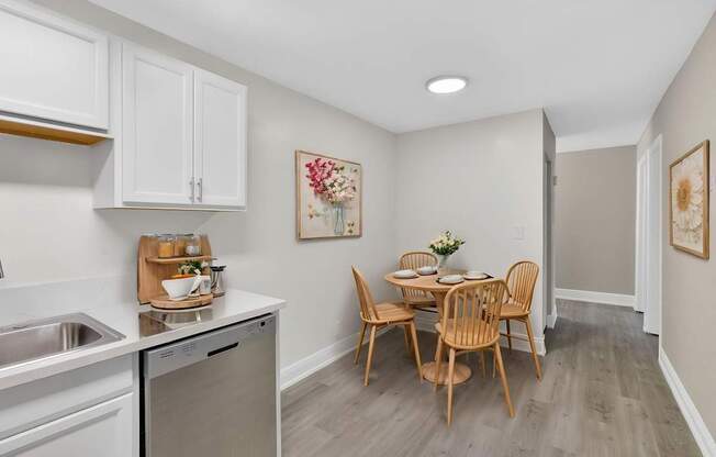 A kitchen with a dining table and chairs.