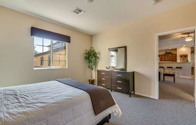 a bedroom with a bed and a dresser and a window