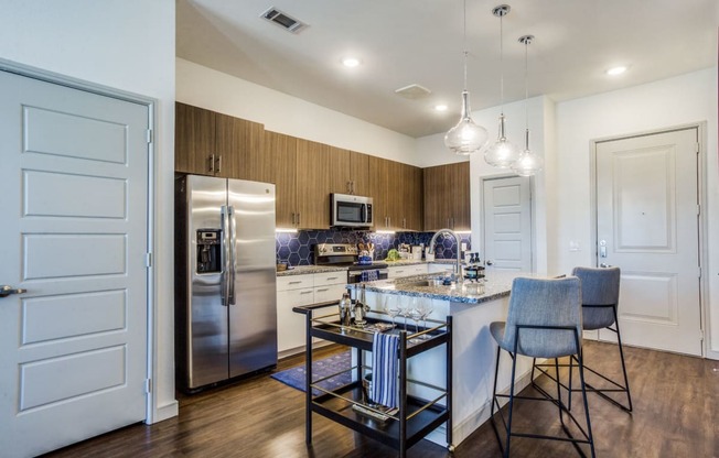 a kitchen with stainless steel appliances and an island with chairs