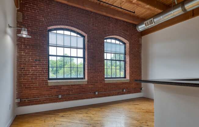 an empty room with two large windows