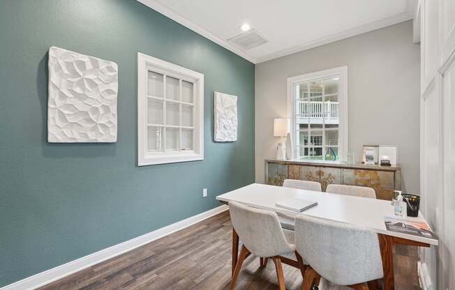 A dining room with a white table and chairs.