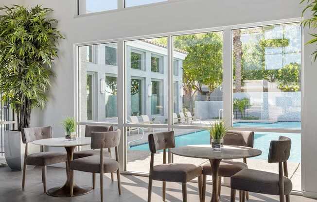 A table with chairs is in front of a glass wall.