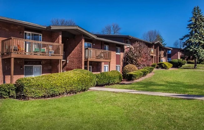 Apartment complex with green lawn and trees.