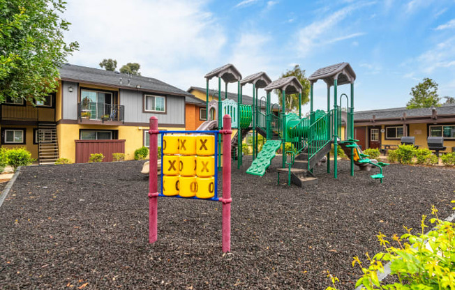 A playground with a sign that says "Kids Play Area" in front of a building.