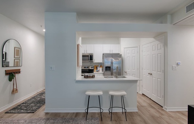 a kitchen with a breakfast bar and stools in a 555 waverly unit