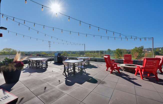a rooftop patio with chairs and tables on a sunny day