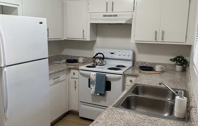a small kitchen with a white counter top and a sink
