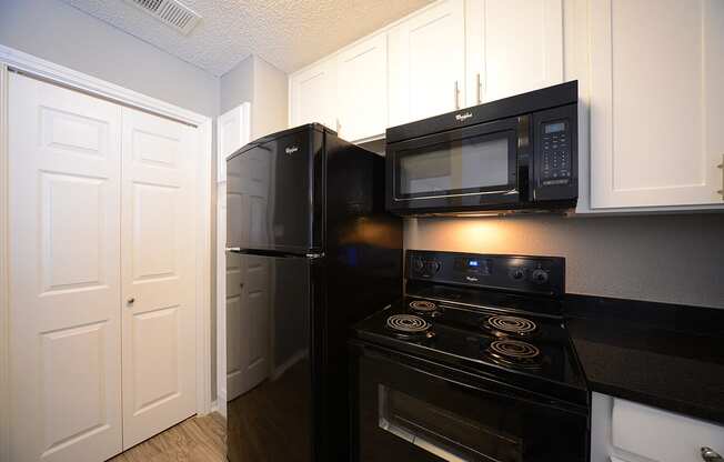 The Trellis at Lake Highlands kitchen area with refrigerator, stove, and cabinets 