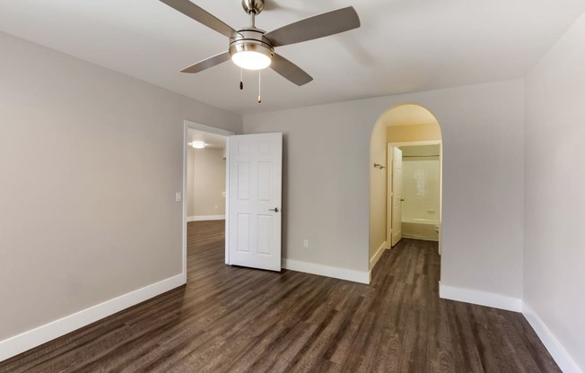Indulge in the allure of hardwood floors and the gentle breeze of a ceiling fan in our cozy bedroom at Boulders at Lookout Mountain Apartment Homes, Phoenix, AZ 85022