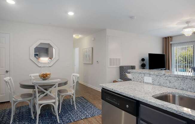 A kitchen with a table and chairs and a mirror on the wall.