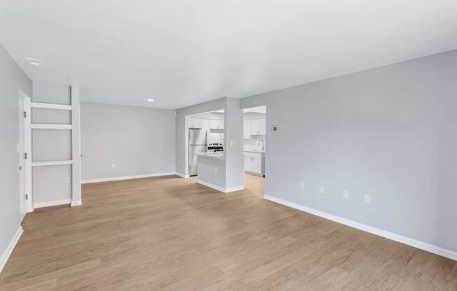 a living room with a hard wood floor and a kitchen