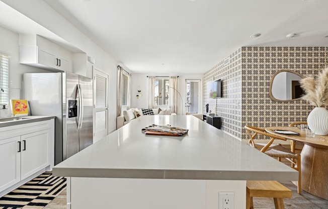 a kitchen with a white counter top and a stainless steel refrigerator