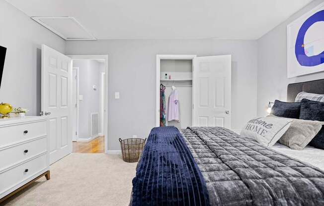 A bedroom with a large bed and a dresser.
