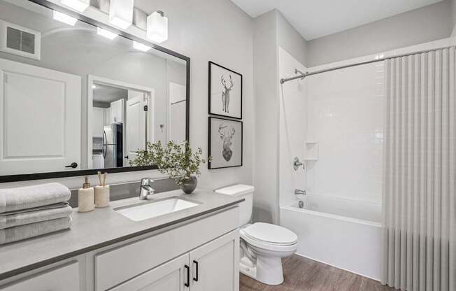 A bathroom with a white toilet, sink, and bathtub.