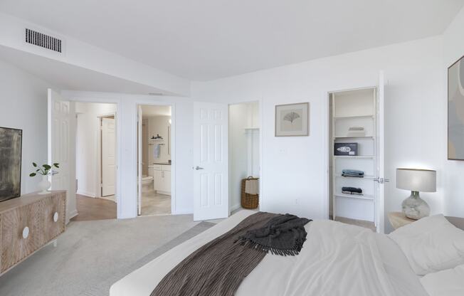 a bedroom with a bed and a dresser and a bathroom