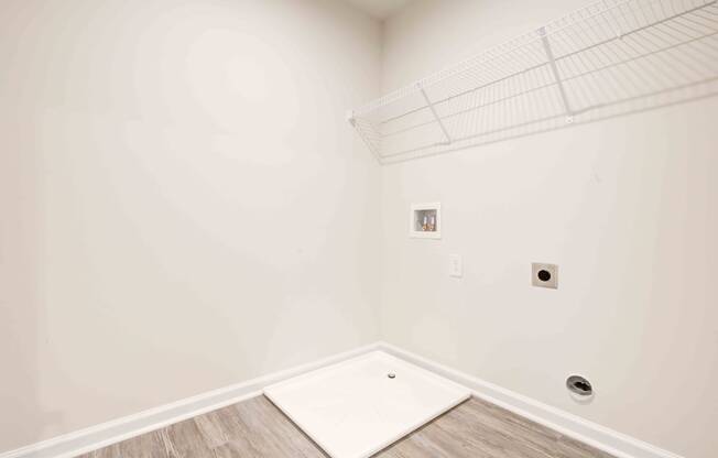 a room with white walls and wood flooring and a white shower