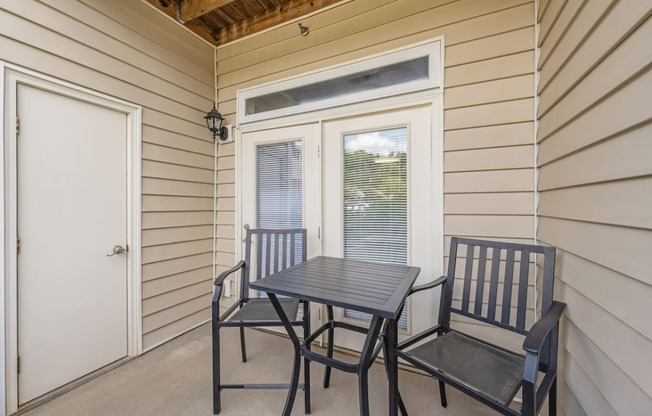 a balcony with a table and chairs and a door