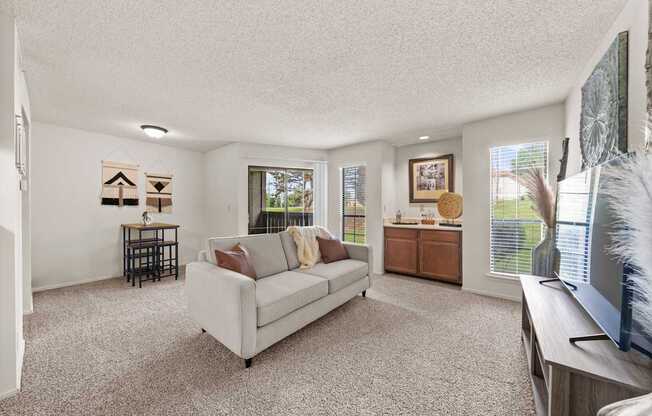 A living room with a couch, a television, and a window.