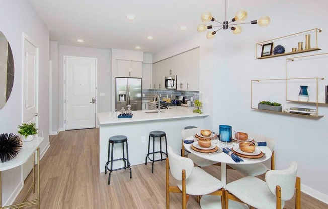 a dining area with a table and chairs next to a kitchen at The Enclave, Jersey City