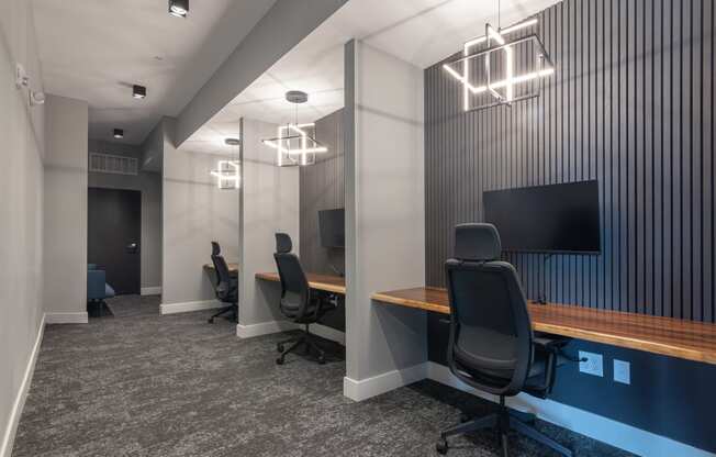 two desks in a room with chairs and a tv