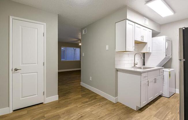 an empty kitchen with a sink and a refrigerator