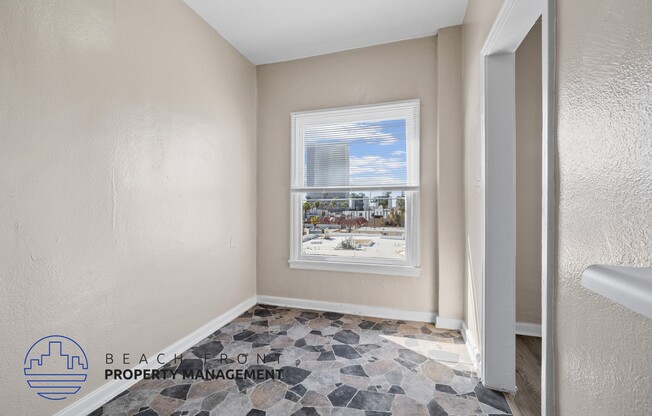 A room with a view of a cityscape through a window.