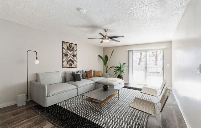 Model Living Room with Wood-Style Flooring and Sliding Glass Door at Indigo Park Apartments in Albuquerque, NM.