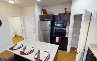 a kitchen with a table and chairs and a stainless steel refrigerator