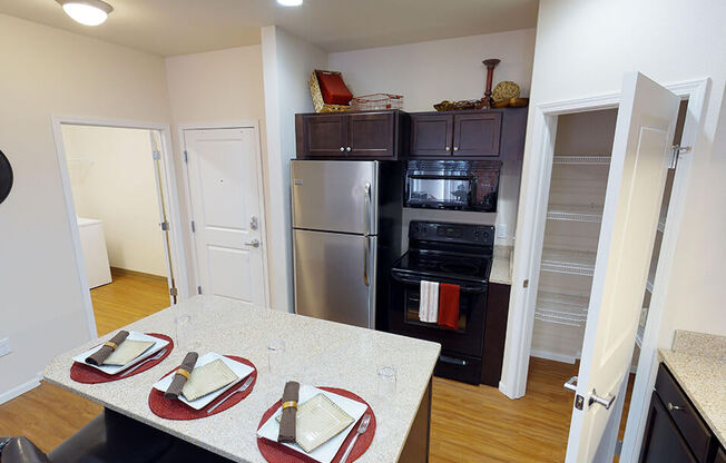 a kitchen with a table and chairs and a stainless steel refrigerator