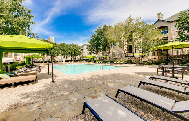 View of Pool Area, Showing Loungers, Cabanas, Picnic Areas, and Fenced-In Area at Stonebriar of Frisco Apartments