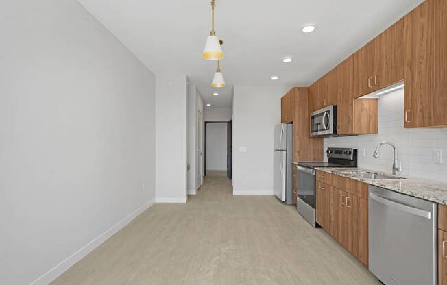 a long kitchen with wood cabinets and stainless steel appliances