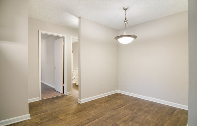 a bedroom with hardwood floors and white walls