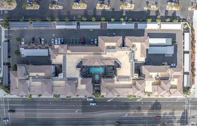 An aerial view of a parking lot and a building with a large entrance.
