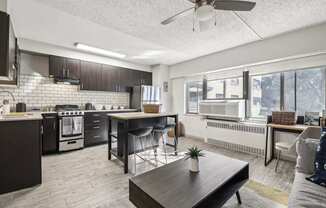 an open kitchen and living room with a table and chairs at Archer Tower in Denver, CO