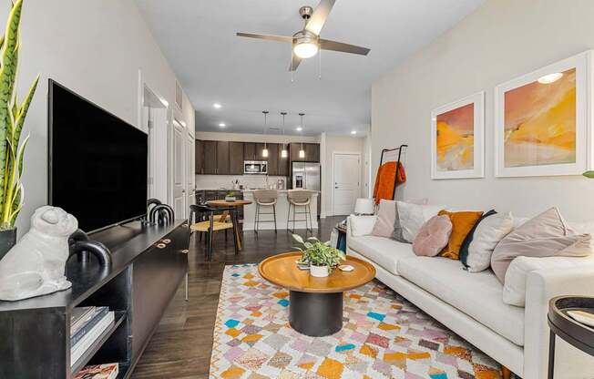 A living room with a white couch and a ceiling fan.