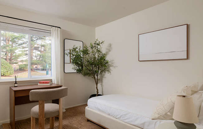 A bedroom with a bed, desk, and chair.