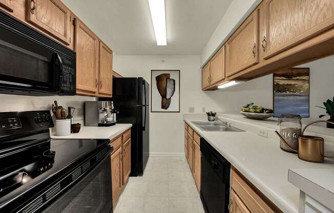 a kitchen with wood cabinets and black appliances and white counter tops