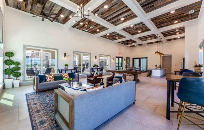 A spacious living room with a large grey sofa and a wooden coffee table.