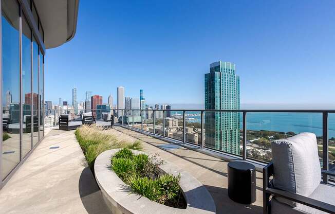 A balcony with a view of the city and the ocean.