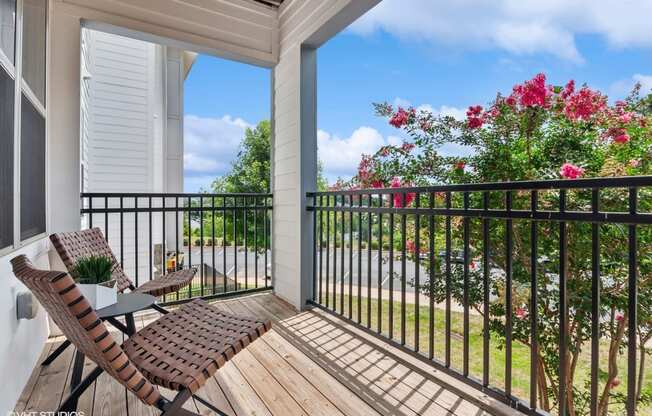 a patio with two chairs and a table on a balcony